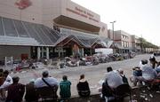 Flood victims sit Sunday outside the Ernest N. Morial Convention Center in New Orleans, awaiting evacuation from the city. The Lawrence-based Golf Course Superintendents Association of America still plans to conduct its annual Education Conference and Golf Industry Show in February at the center, but is looking into relocation options.