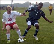 Lawrence High's Kevin Calton, left, battles Free State's Kyle Ceesay for possession during the first half of Thursday night's game at the Youth Sports Inc. fields. Free State won the game, 2-1.