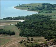 This aerial photograph shows the area of Sesquicentennial point, at bottom of the frame, with a temporary road leading to the point. Visible at the top of the photograph is Clinton Lake.