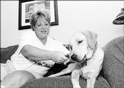 Kelli Church, of Critter Sitter, gives a bone to Tucker, a dog she visits at lunchtime for walks and playtime. Pet sitters are a comforting alternative for families who don't wish to put animals in kennels during vacation or even the workday.