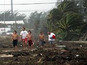 A group of boys walk down the middle of a debris and sand strewn section of U.S. Highway1 as Hurricane Rita passes through Tuesday in Islamorada, Fla. Hurricane Rita raked the Florida Keys on Tuesday with high winds and torrential rains as it pushed into the warm waters of the Gulf of Mexico, where forecasters said the storm is likely to grow into a major hurricane that could eventually strike Texas or Louisiana.
