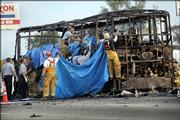 Firefighters work to cover the bodies of those who died early Friday morning when the bus they were traveling in caught fire in the northbound lanes of Interstate 45 in Wilmer, Texas. The bus, carrying nursing home residents fleeing from Hurricane Rita, caught fire and was rocked by explosions, killing as many as 24 people, authorities said.