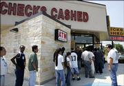 A line forms around the outside of a check-cashing business Thursday in Houston as people prepared for the arrival of Hurricane Rita. Many of the people in line were unable to get checks cashed as the business ran out of cash. Experts say ready access to financing is important during any disaster, whether it's a hurricane, flooding or job loss.