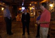 Brad Burke, assistant attorney general with Alcoholic Beverage Control, center, listens to Tom Devlin, right, co-owner of The Hawk, 1340 Ohio, as Burke, Tom Groneman, left, and Kay Ediger, also with ABC, make a walk-through inspection of the Lawrence bar Wednesday afternoon. The ABC is seeking to revoke the liquor license of The Hawk because of repeated underage-drinking citations.