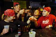 Chi Omega sorority sisters from left, Sam Rasmussen, a Sioux Falls, S.D., senior, Lindsey Jones, a Prairie Village senior, Laura Wolowicz, a Frisco, Texas, senior, and Jacquelyn Roemeling, a Wichita senior, take shots at The Hawk on Wednesday after delivering invitations to an upcoming pirate-theme party. The Kansas Alcoholic Beverage Control wants to revoke the bar's liquor license after citing the bar 18 times in the past three years for serving alcohol to minors.