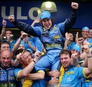 Fernando Alonso, center, celebrates with members of his team after he was crowned world champion. Alonso placed third in the Brazilian Formula One Grand Prix on Sunday in Sao Paulo, Brazil.