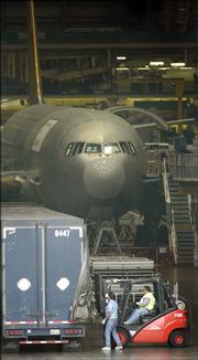 Boeing Co. workers unload parts from a truck Friday at the company's aircraft assembly plant in Everett, Wash., one day after striking Machinist Union workers voted to approve a new labor contract. The agreement ended a four-week strike that shut down Boeing's commercial airplane assembly plants.