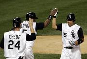 Tadahito Iguchi, right, accepts congratulations from teammates Joe Crede (24) and Juan Uribe (5) after hitting a three-run fifth-inning homer. The White Sox defeated the Red Sox, 5-4, Wednesday in Chicago to take a 2-0 series lead.