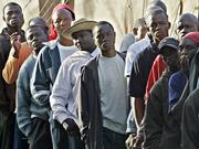 African immigrants wait for breakfast at a holding center in the Spanish enclave of Melilla. Immigrants defied increased security to stage another rush at the border between Morocco and Spain on Wednesday, the fifth attempt in a week.
