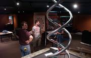 Mark Anderson, of the Science Museum of Minnesota in St. Paul, left, who was contracted to set up the "Explore Evolution" exhibit at the Natural History Museum, surveys the construction Sept. 21 with Kansas University students and exhibit assistants Derick Schweppe, Topeka, and Jessica Braker, St. Louis. In the center sits a DNA double helix, which will showcase some of the past and present research methods on evolution.
