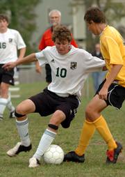 Free State's Greg Glatz, left, works the ball against Shawnee Mission West's Logan Murphy during Tuesday's match at Free State.