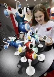 Stephanie Glaser, of East Northport, N.Y., connects an iPod to an iZ, by Zizzle, and watches it react to the music during Toy Wishes Magazine Holiday Preview Thursday in New York. Toy retailers are prepared for a difficult season, and are planning big discounts and other promotions.
