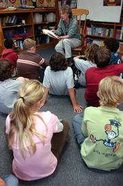 Quail Run SChool librarian Jane Imber reads to a group of fifth-graders who chose to skip their recess to hear "Stumptown Kid" by Carol Gorman, an author who will be visiting the school later this month. Quail Run students received high marks on their reading skills during state tests.