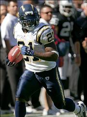 San Diego's LaDainian Tomlinson rushes for a first-quarter TD in the Chargers' 27-14 victory against the Raiders. Tomlinson tied an NFL record by scoring a touchdown in his 18th straight game, and then became the seventh player to run, catch and throw for a touchdown in the same game on Sunday in Oakland.
