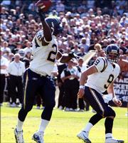 San Diego's LaDainian Tomlinson throws for a second-quarter touchdown in the Chargers' 27-14 victory against the Raiders. Tomlinson tied an NFL record by scoring a touchdown in his 18th straight game, and then became the seventh player to run, catch and throw for a touchdown in the same game on Sunday in Oakland.