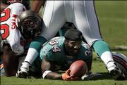 Miami's Ricky Williams, center, comes up without his helmet after taking a handoff during the first quarter against the Buccaneers. The Dolphins lost, 27-13, Sunday in Tampa, Fla.