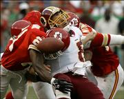 Washington Redskins quarterback Mark Brunell, center, fumbles the ball as he is hit by Kansas City's Jerome Woods, left, and Kawika Mitchell in the second quarter. Jared Allen recovered the fumble, helping the Chiefs beat the Redskins, 28-21, on Sunday at Arrowhead Stadium in Kansas City, Mo.