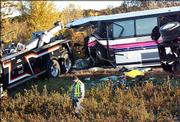 The wreckage of a bus that was transporting students from Chippewa Falls High School is readied to be removed Sunday near Osseo, Wis., after it collided with a semi truck. Five people on the bus were killed and 29 others were transported to the hospital.