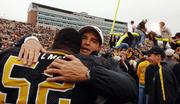 Missouri coach Gary Pinkel, right, hugs offensive lineman Tony Palmer as a goalpost is brought down. The Tigers beat Nebraska, 41-24, Saturday in Columbia, Mo.