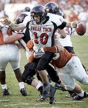 Texas defender Brian Robinson tackles Texas Tech quarterback Cody Hodges (10). The Longhorns beat the Red Raiders, 52-17, Saturday in Austin, Texas.