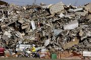 A motorcyclist rides Saturday past a mountain of trash, sheet rock and domestic furniture removed from homes damaged by Hurricane Katrina, at one of three dump areas set up for that purpose, in New Orleans, La.