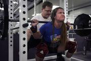 Cheryl Anderson attempts a power lift as Neal Anderson helps to spot her safety and progress. Anderson is 30 years old and weighs 97 pounds, and she has won some prestigious powerlifting medals.