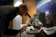Marvin Hunt, assistant dean of continuing education at Kansas University, peeks through a microscope Oct. 25 at the Natural History Museum&squot;s "Explore Evolution" exhibit, which opened Nov. 1.