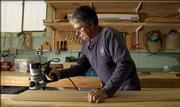 Jack McCartney, a carpenter for the Lawrence school district, sands lumber Thursday in the district's maintenance facility, 146 Maine.