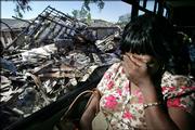 Beverly Evans covers her eyes as she rides Thursday through her neighborhood in the Lower Ninth Ward for the first time since it was devastated by Hurricane Katrina.