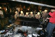 Firemen turn over a vendor's table at the site of a blast in New Delhi, India. A series of explosions shook the city Saturday evening, tearing through markets packed with shoppers ahead of an upcoming Hindu festival, officials said.