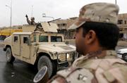 A U.S. soldier gestures from a humvee as he patrols a street Saturday in Baghdad, Iraq. The campaign for Iraq's parliamentary election effectively began Saturday for the 18 candidates.
