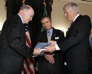 Treasury Secretary John Snow, left, accepts a report from Connie Mack, chairman of the President's Advisory Panel on Federal Tax Reform. The panel presented recommendations Tuesday for two designs that would rewrite virtually every tax law for individuals and businesses. Sen. John Breaux, D-La., center, is the panel's vice chairman.