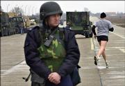 An unidentified U.S. Army member jogs as a Romanian anti-terrorist squad soldier looks on in at the Mihail Kogalniceanu air base. Human Rights Watch in New York said Thursday it had evidence indicating the CIA transported suspected terrorists captured in Afghanistan to Poland and Romania.