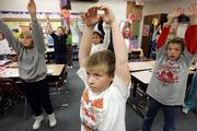 Fifth-graders, including, from front left, Emily Jacobs, Dalton Meyer and Jacob Richardson, participate in a morning stretch recently in Cindy Merten's class at Challenger Intermediate School in Goddard.