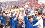 Elated KU fans carry a goal post out of Memorial Stadium after a
40-15 Jayhawk victory over Nebraska. Saturday was the second time
in a week that fans made off with the goal posts. The first time
was last Saturday after KU defeated Missouri 13-3.
