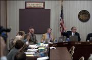 Kansas Board of Education representatives raise their hands Tuesday afternoon in favor of adopting the new science standards at the Board of Education Building in Topeka. The measure passed with a vote of 6-4.