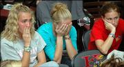 Jayhawks, from left, Nicole Braman, Erin Ferguson and Nikki Alvarez, react Monday after learning they wouldn't play in the NCAAs.