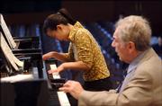 Yale School of Music masters student Xinyu Chen, left, performs Thursday during class under the instruction of professor Claude Frank in New Haven, Conn. After receiving a $100 million donation, the School of Music will fully subsidize students' tuition beginning next year.