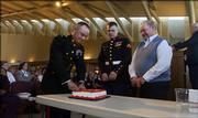 Maj. Jeff Daniels cuts a slice of cake for Marines Lance Cpl. Ryan Chapman, 23, Lawrence, center, and Charley Henson, 88, retired, Lawrence, during a ceremony Thursday morning celebrating the 230th birthday of the U.S. Marine Corps at the Dole Institute of Politics.