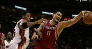 Miami forward Wayne Simien, left, tries to gain control of the ball as Houston center Yao Ming stretches for the rebound. The Heat won, 88-84, Thursday in Miami.