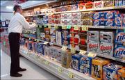 Kevin Green, manager of store operations at the Hy-Vee at 4000 W. Sixth St., straightens up the beer selection. Grocery and convenience stores in Lawrence can now sell beer on Sundays.