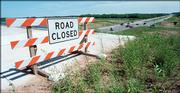 A sign marks the edge of the South Lawrence Trafficway bridge, often called the Bridge to Nowhere, because it does not extend east of U.S. Highway 59, at right. City commissioners Tuesday night agreed to endorse a plan to build the South Lawrence Trafficway through the Baker Wetlands, an area that American Indians and others consider sacred.