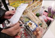 Carolyn Ewing checks her grocery list Friday at a Chicago supermarket. Consumers who braced for steeper costs because of the recent spike in energy prices can relax a little when they head to the supermarket for the Thanksgiving holiday: Stiff retail competition has kept stores from risking big markups.