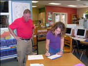 Sherry Emerson, of Pet World, signs an agreement Oct. 4 to become a Lawrence Education Achievement Partner with Broken Arrow School as the school's principal, Larry Bakerink, looks on. As a partner with Broken Arrow, employees will support the education of nature and animals in a variety of ways.