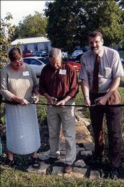 From left, Julie Coleman, of Kansas Department of Health and Environment; Charles Jones, Douglas County commissioner; and Daryl Buchholz, associate director for Extension and Applied Research at Kansas State University, participate in a ribbon-cutting ceremony for the rain garden at the Douglas County Extension office. The dedication was part of the Douglas County Extension Showcase on Sept. 22.