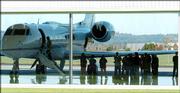 Passengers, crew and others stand by a Nike Corporate jet after a safe landing Monday in Hillsboro, Ore. The Nike corporate jet carrying its CEO and six other people developed landing gear problems shortly after takeoff Monday but then made a safe emergency landing after the gear was unstuck.