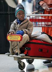 Demaine Williams, 5, rides on a luggage cart at Hartsfield Jackson Atlanta International Airport in Atlanta, as he and his family return home to Nassau, Bahamas, after visiting in Atlanta. Airport officials were expecting some 285,000 people to pass through Hartsfield Jackson on Tuesday, one of the busiest travel days leading up to Thanksgiving.