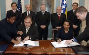 Secretary of State Condoleezza Rice, seated at right, and Bosnian Foreign Minister Mladen Ivanic, seated at left, sign a Status of Forces Agreement and an Open Skies Agreement at the State Department on Tuesday in Washington. In the back row are the Croat member of the Bosnian three-member presidency, Ivo Miro Jovic, center, Sulejman Tihic, second from left, the Bosnian Muslim member, and Borislav Paravac, the Serb member, second from right. Others are unidentified.