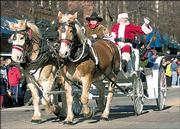 SANTA CLAUS greets spectators from a horse-drawn carriage during the 2004 Lawrence Old-Fashioned Christmas Parade. CornerBank assumed leadership of the parade last year and also will coordinate the 2005 event, which will be Dec. 3.