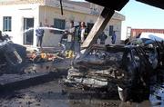 Iraqi firefighters spray water on burned cars after a suicide bomber killed 12 people Saturday when he drove his pickup into a crowded gasoline station in Samarra, Iraq.